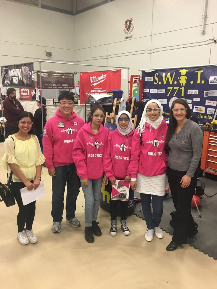 Marisa Sterling with students and a mentor at a high school robotics competition